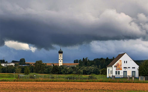 Drohende Wassermassen über dem Wasserwerk in Thannhausen - und der Ursberger Kirchturm scheint gute Miene zum gefährlichen Spiel zu machen