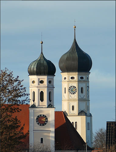 "Auf Tuchfühlung". Durch das Teleobjektiv gesehen kommen sich der Bayersrieder- und der Ursberger Kirchturm (im Hintergrund) sehr nahe - doch der Schein trügt, sie sind 795 m (Luftlinie, mit Google gemessen) voneinander entfernt.